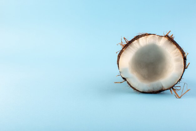 Вид сверху на кокосовые орехи нарезанный молочно-свежей спелой, изолированный на ледяной синий