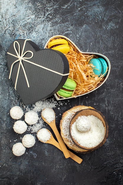 Free photo top view coconut candies with french macarons on a gray background cake holiday gift red love couple valentines day sweet goodie color