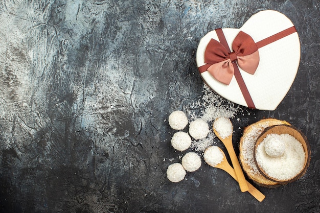 Вид сверху кокосовые конфеты с подарком на сером фоне праздник красная любовь пара лакомство день святого валентина чай подарок цвет сладкий свободное пространство