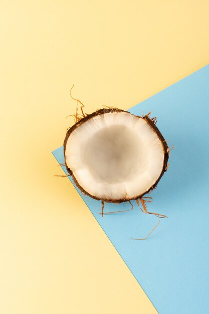 A top view coconuts sliced milky fresh mellow isolated on the cream-iced-blue colored