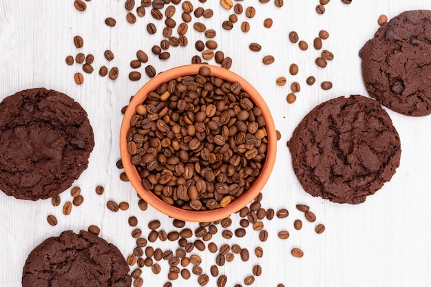 top view coffee beans and chocolate cookies on white surface