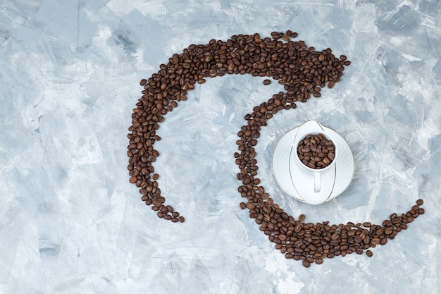 Top view coffee beans in cup on grey plaster background. horizontal