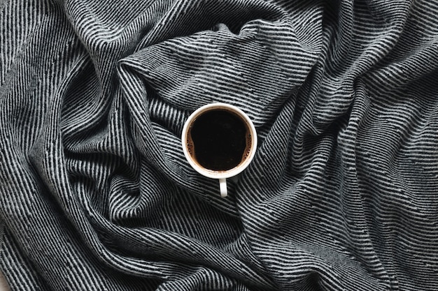 Top view of a coffee cup on stripe pattern cloth