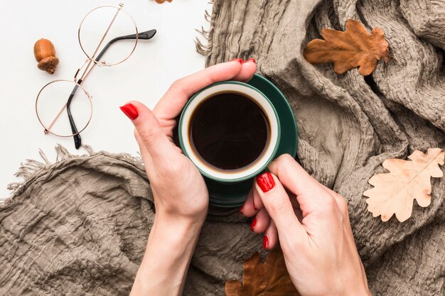 Top view of coffee cup with autumn leaves and blanket