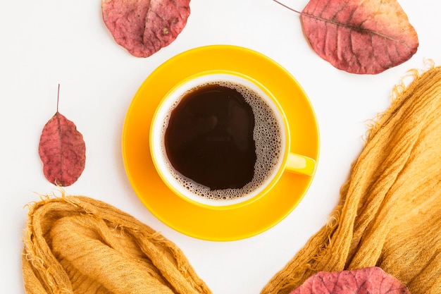 Top view of coffee cup with autumn leaves