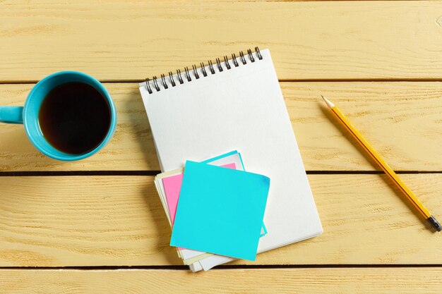 Top view. coffee cup with coffee. pen putting on blank notebook.