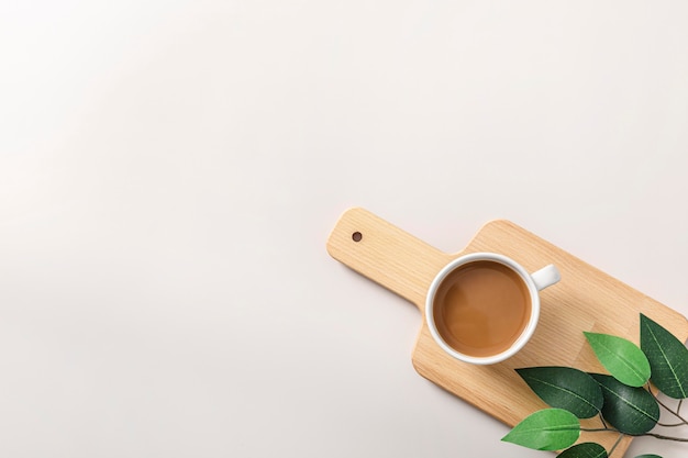 Top view of coffee cup on wooden chopping board with copy space