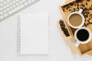 Free photo top view of coffee cups with notebook