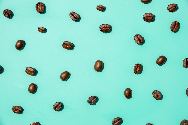 Top view coffee grains on green background