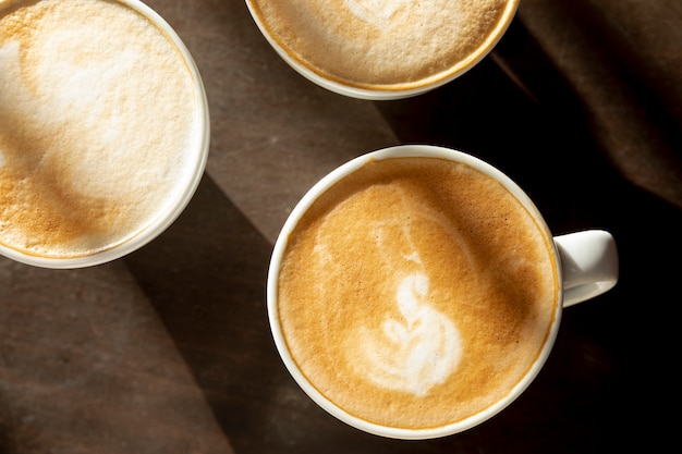 Top view coffee mugs with milk on the table