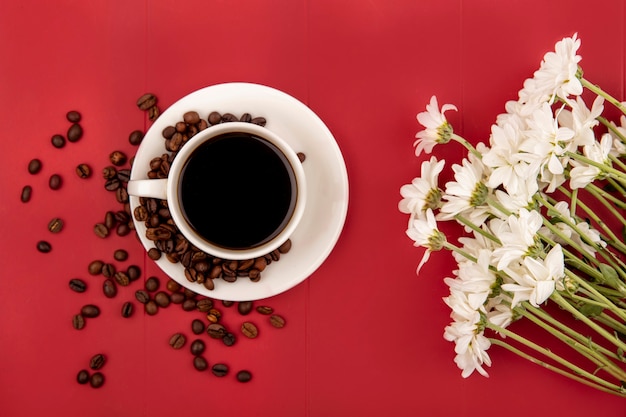 Top view of coffee on a white cup with coffee beans on a res background