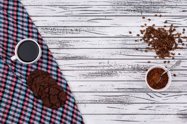 Top view of coffee with cookies and copy space on white wooden background horizontal