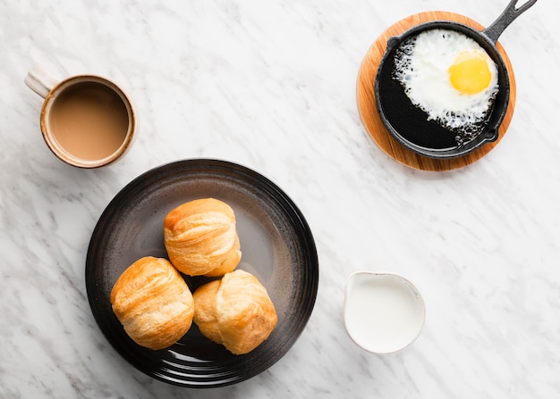 Top view collection of breakfast eggs in pan next to bread