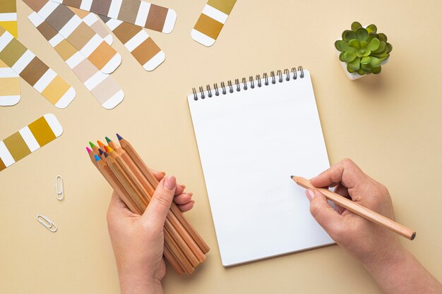 Top view of color palette for house renovation with notebook and colored pencils