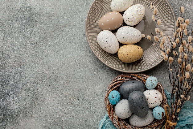 Top view of colored easter eggs in basket and plate with copy space