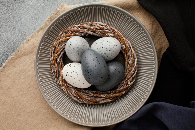 Top view of colored easter eggs in basket on plate