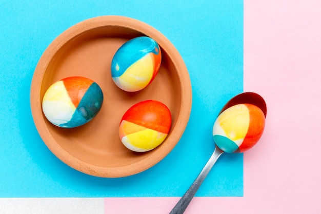 Top view of colored eggs for easter on plate with spoon