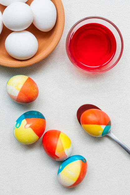 Top view of colored eggs with paint and spoon for easter