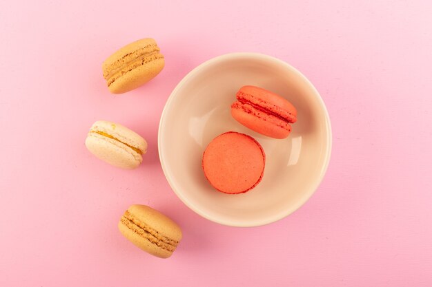 A top view colored french macarons inside and outside plate on the