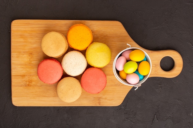 A top view colored french macarons with colorful candies