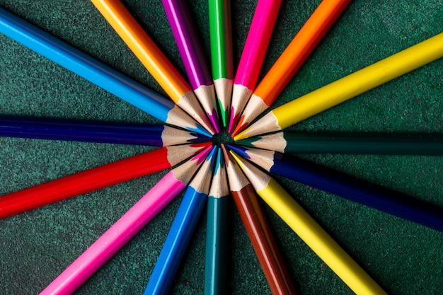 Free photo top view of colored pencils arranged on dark