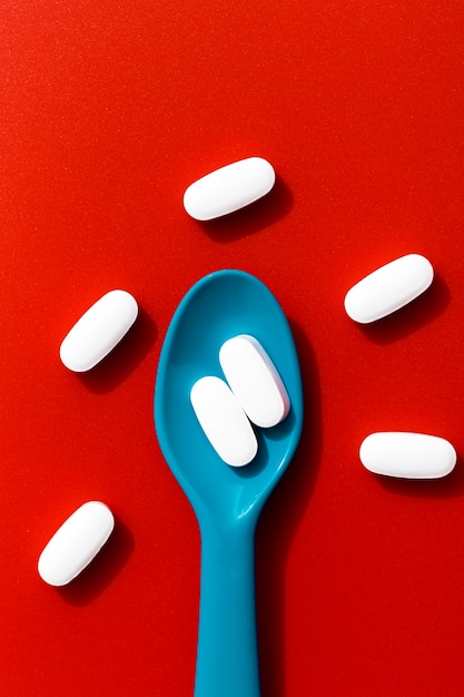 Free photo top view of colored spoon with pills