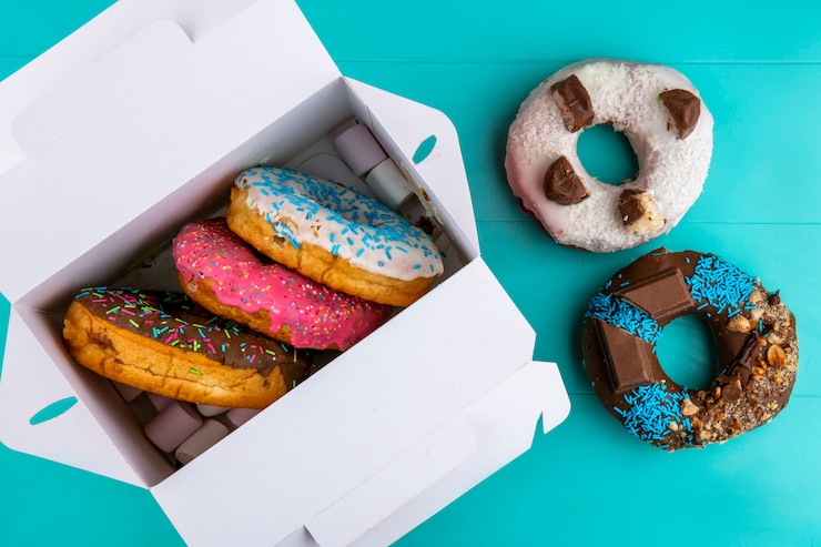 Free Photo top view of colored sweet donuts in a box on a turquoise surface