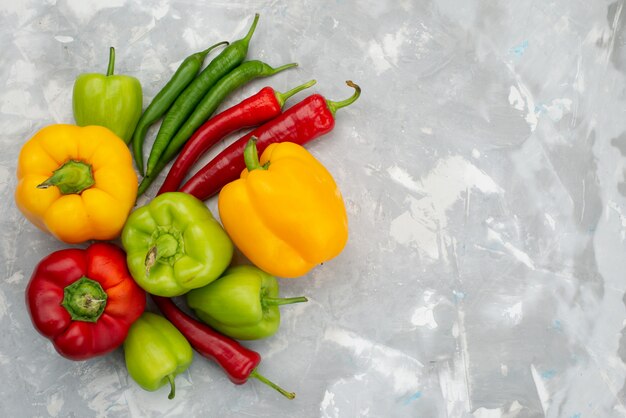 Top view colorful bell-peppers with peppers on grey table