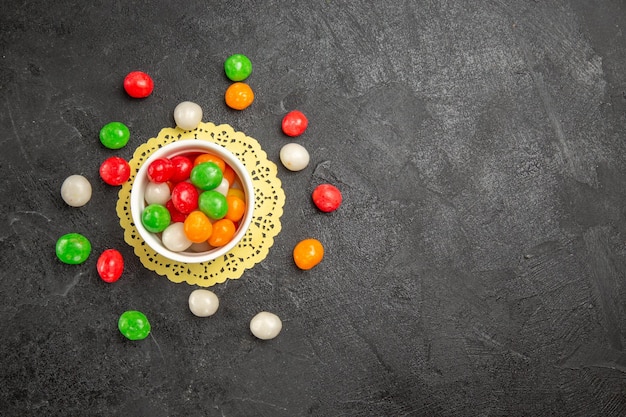 Top view colorful candies on a dark background color rainbow sweet tea