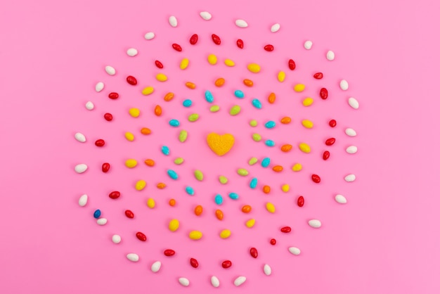 A top view colorful candies forming a circle on pink