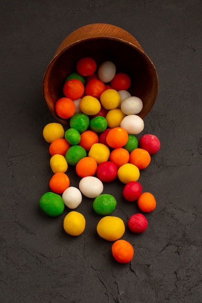 top view colorful candies inside brown pot on the dark floor