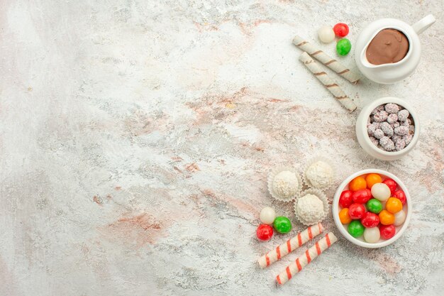 Top view colorful candies with cookies on the light white background color rainbow biscuit tea cake