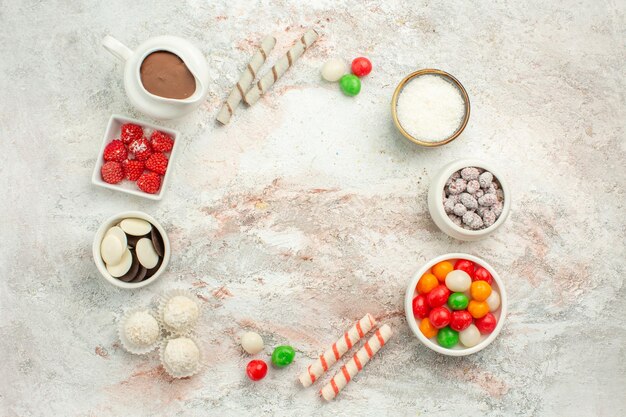 Вид сверху красочные конфеты с печеньем на белом фоне печенье сладкий торт печенье