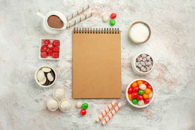Вид сверху красочные конфеты с печеньем на белом фоне цветной радужный бисквитный чайный торт