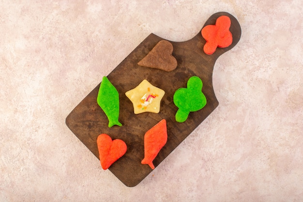 Free photo top view of colorful delicious cookies different formed on the brown wooden desk