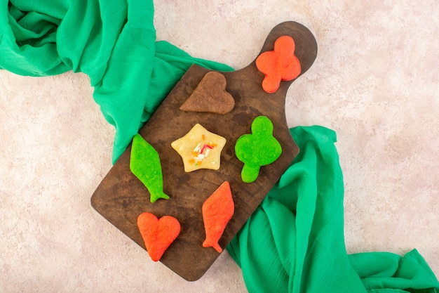 Free photo top view of colorful delicious cookies different formed on the brown wooden desk