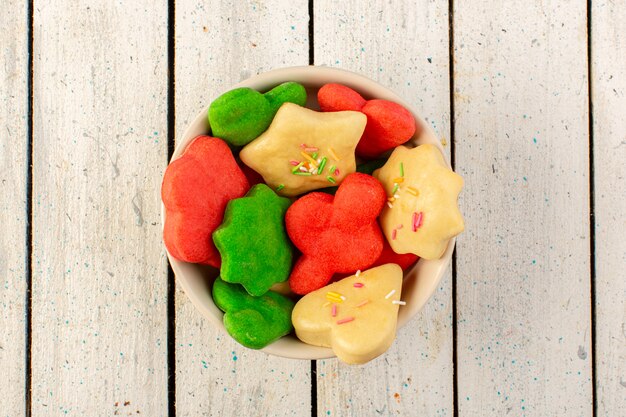 Top view of colorful delicious cookies different formed inside round plate