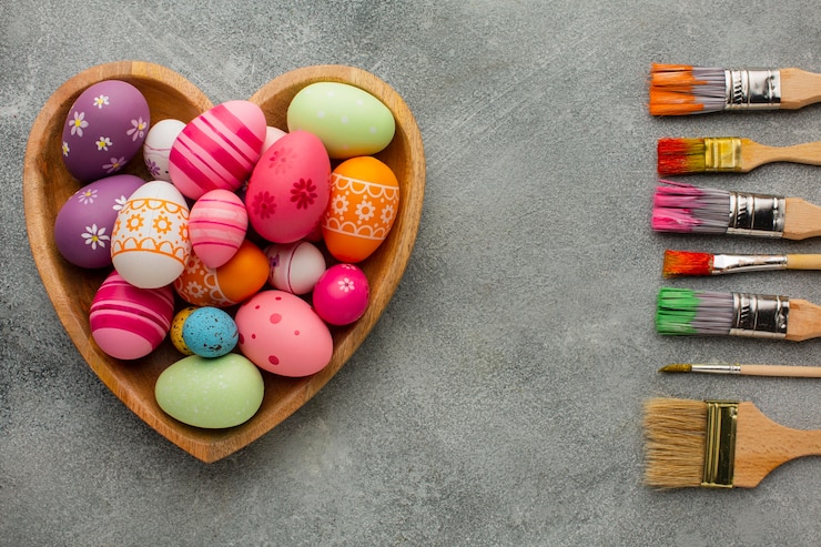 Free Photo top view of colorful easter eggs in heart shaped plate with assortment of paint brushes