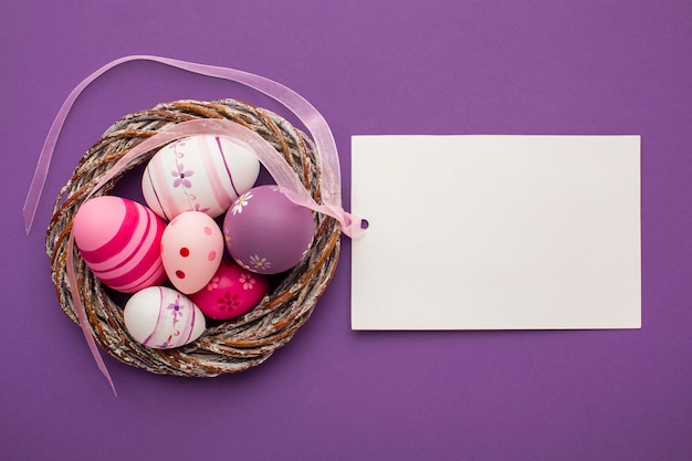 Top view of colorful easter eggs with basket and paper