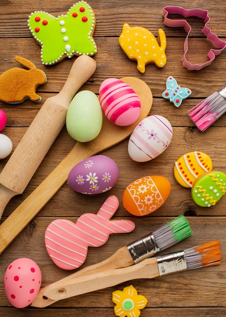 Vista dall'alto di uova di Pasqua colorate con utensili da cucina e forme di coniglietto