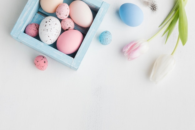 Top view of colorful eggs for easter with tulips