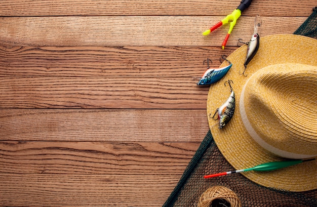Top view of colorful fishing bait with copy space and hat