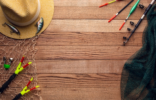 Top view of colorful fishing essentials with net and hat