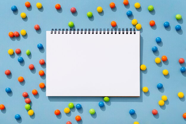 Top view of colorful jelly beans with notebook