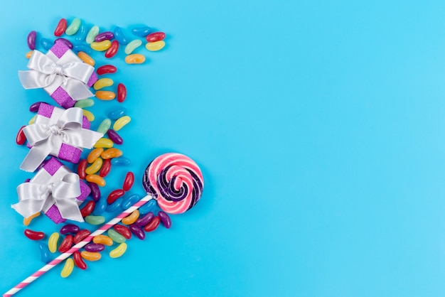 青、砂糖菓子キャンディーに小さなマーマレードと紫のギフトボックスと平面図のカラフルなロリポップ