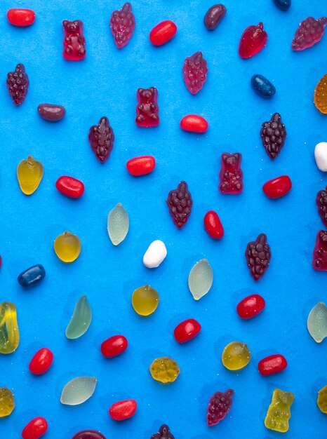 Top view of colorful marmalade jelly candies on blue