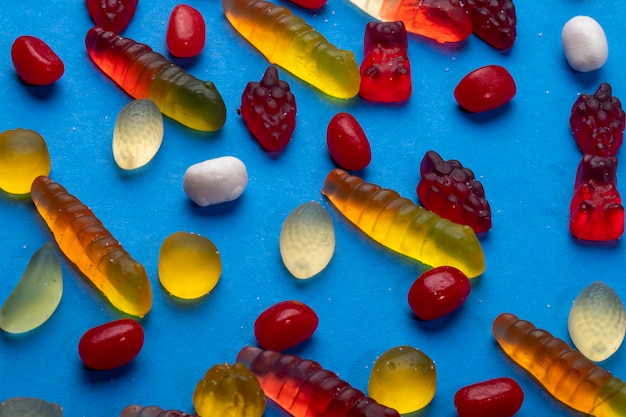 Top view of colorful marmalade jelly candies on blue