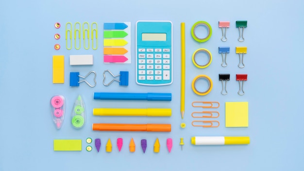 Top view of colorful office stationery with calculator and paper clips