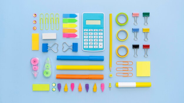 Top view of colorful office stationery with calculator and paper clips