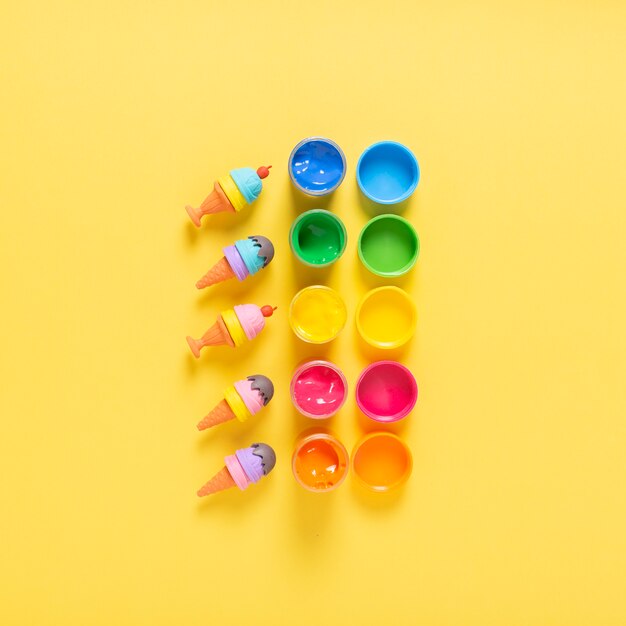 Top view of colorful paint on yellow background